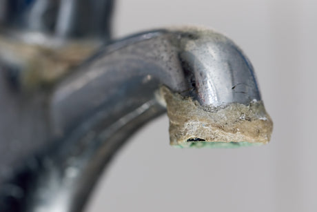 Scale build-up on water faucet cause by calcium in water